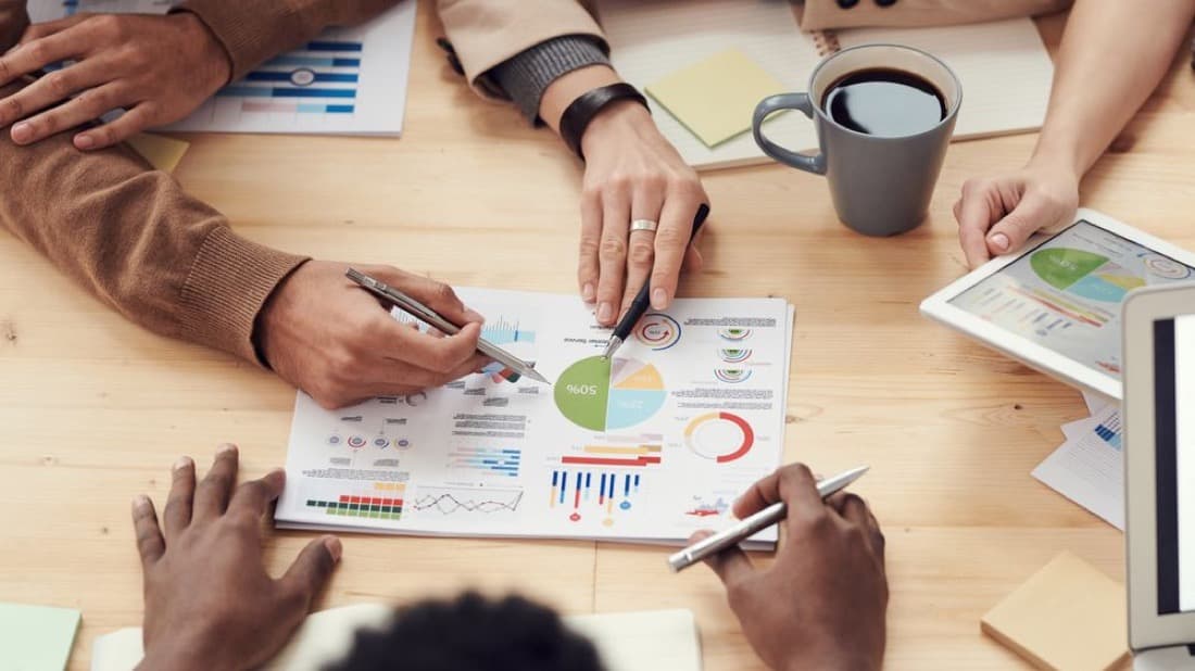 Charts and reports spread across a table during a business review