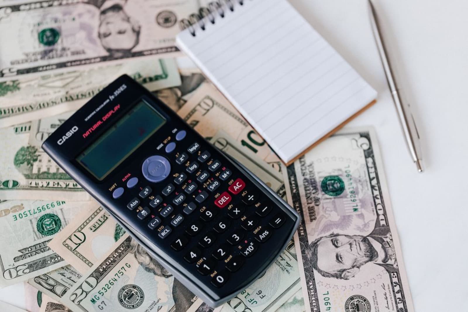 A calculator resting on a spread of US dollar bills